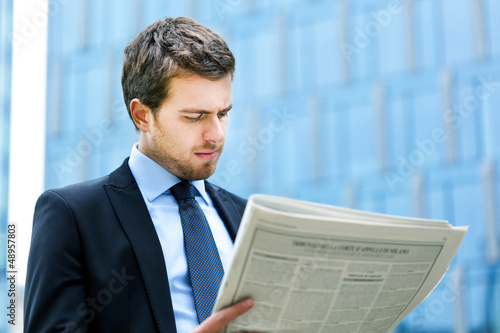 Photo: Business man reading a newspaper Business man reading a newspaper