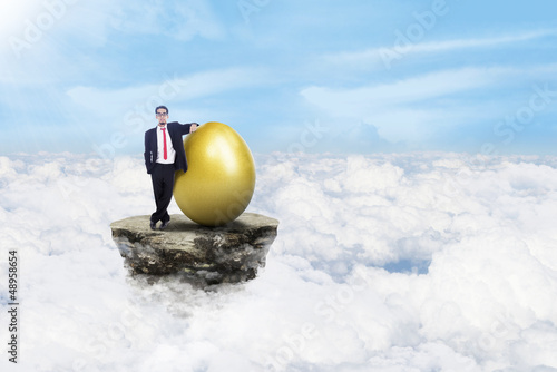 Photo: Businessman and gold eggs on clouds Businessman and gold eggs on clouds