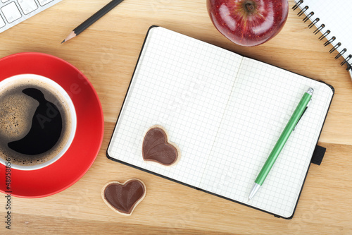 Photo: Coffee cup, cookies, red apple and office supplies Coffee cup, cookies, red apple and office supplies