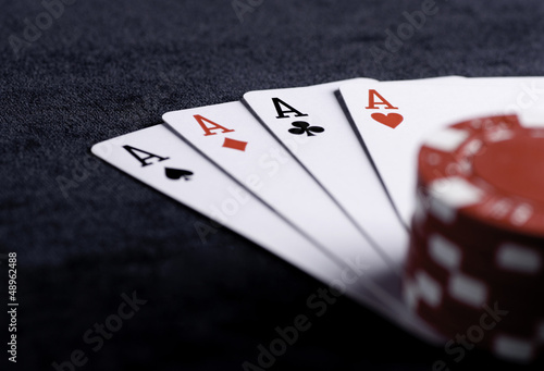 Photo: four aces high on black table with chips four aces high on black table with chips