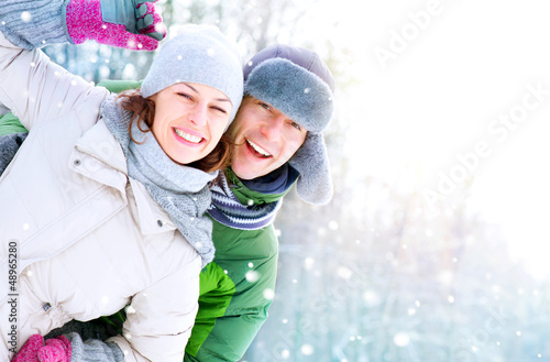 Photo: Happy Couple Having Fun Outdoors. Snow. Winter Vacation Happy Couple Having Fun Outdoors. Snow. Winter Vacation