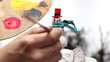 man painting buttons on a snowman miniature