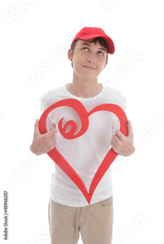 Photo: Daydreaming boy holding red love heart Daydreaming boy holding red love heart