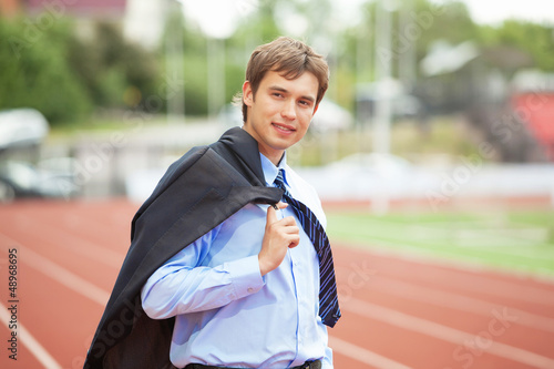 Photo: Businessman at athletic stadium and race track Businessman at athletic stadium and race track