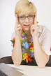 Blond Woman Sitting At Desk And Wearing A Lei