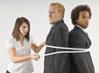 Woman Tying Two Businessmen Together With A Rope