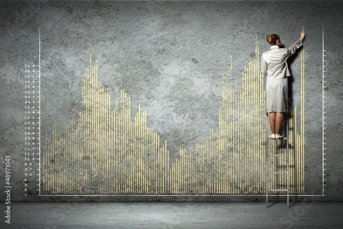 Photo: businesswoman drawing diagrams on wall businesswoman drawing diagrams on wall