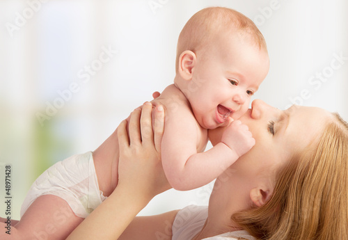 Photo: Happy young mother kissing a baby Happy young mother kissing a baby