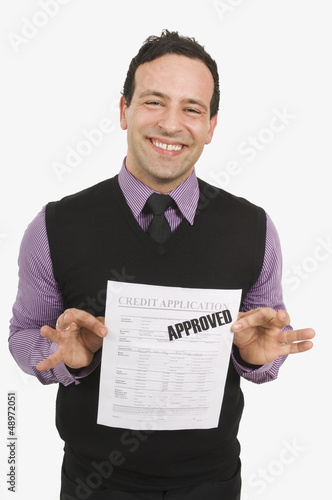 Photo: Man Holding Approved Credit Application Man Holding Approved Credit Application