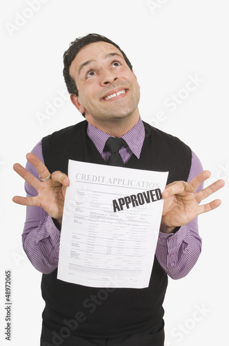 Photo: Man Holding Approved Credit Application Man Holding Approved Credit Application