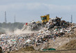 A bulldozer moving garbage on a landfill waste site