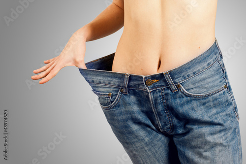 Photo: Jeune femme dans un jean trop grand après un régime réussi Jeune femme dans un jean trop grand après un régime réussi
