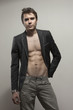 Young good-looking model  in dark suite  with naked torso