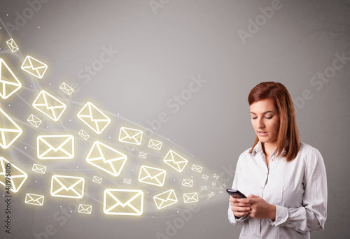 Photo: attractive young lady holding a phone with message icons attractive young lady holding a phone with message icons