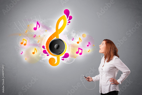 Photo: pretty girl singing and listening to music with musical notes pretty girl singing and listening to music with musical notes