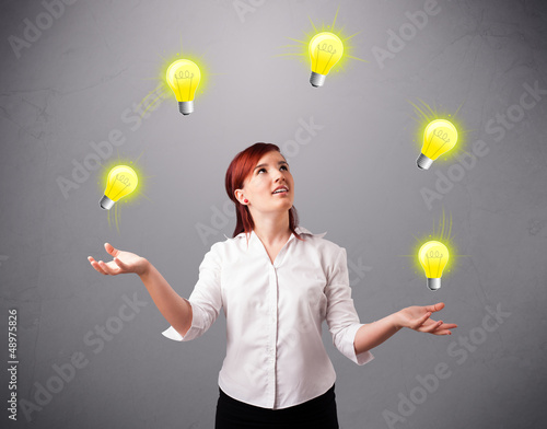 Photo: young lady standing and juggling with light bulbs young lady standing and juggling with light bulbs