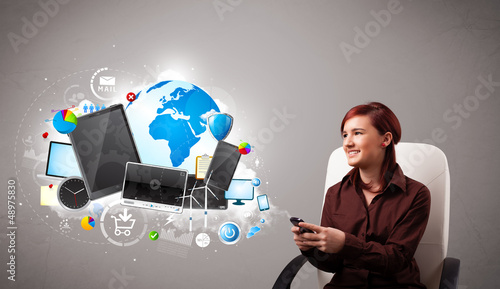 Photo: young woman sitting and browsing on her phone young woman sitting and browsing on her phone