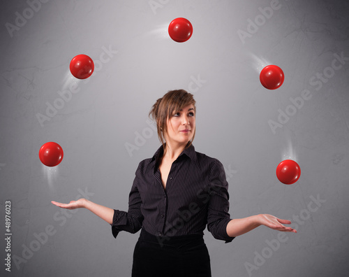 Photo: young girl standing and juggling with red balls young girl standing and juggling with red balls