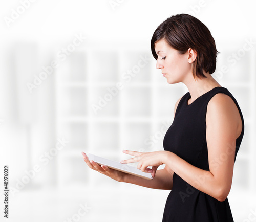 Photo: Young woman looking at modern tablet Young woman looking at modern tablet