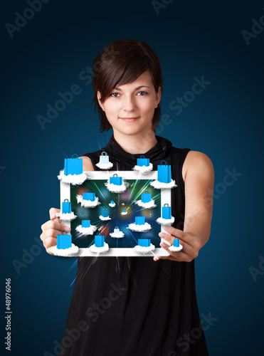 Photo: woman holding modern tablet with colorful shopping bags on cloud woman holding modern tablet with colorful shopping bags on cloud