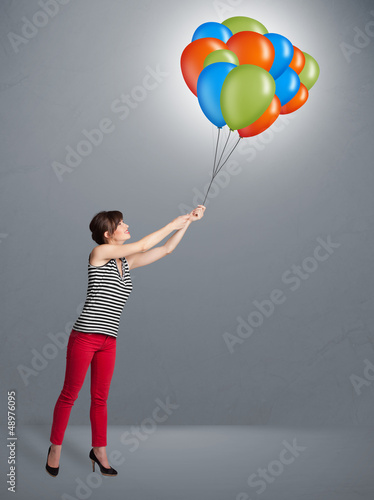 Photo: Young woman holding colorful balloons Young woman holding colorful balloons