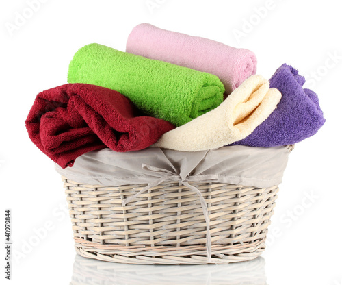 Photo: Colorful towels in basket isolated on white Colorful towels in basket isolated on white