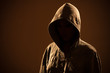 Scary woman with hood in darkness