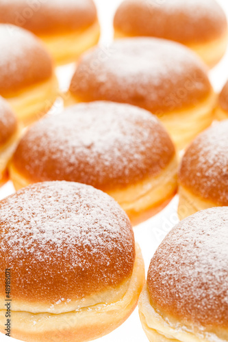 Photo: Viele Krapfen mit Staubzucker nebeneinander Viele Krapfen mit Staubzucker nebeneinander