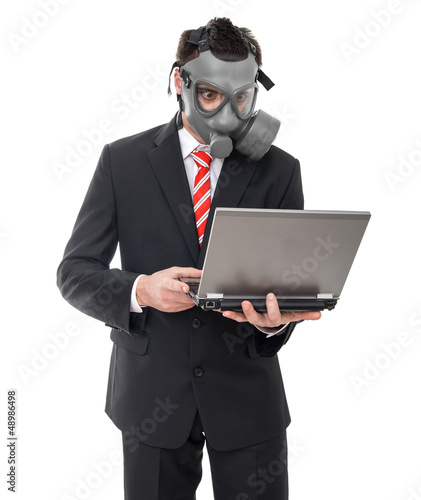Photo: Afraid businessman with gas mask using laptop, isolated on white Afraid businessman with gas mask using laptop, isolated on white