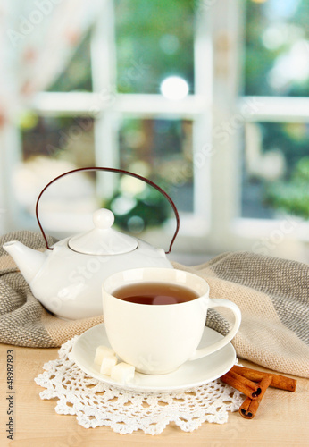 Photo: cup of tea with scarf on table in room cup of tea with scarf on table in room