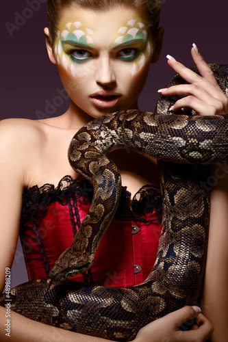 Photo: Serpent. Fantasy. Fancy Woman holding Tamed Snake in Hands Serpent. Fantasy. Fancy Woman holding Tamed Snake in Hands
