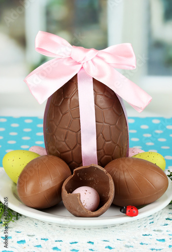 Photo: Composition of Easter and chocolate eggs on window background Composition of Easter and chocolate eggs on window background