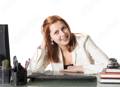 Photo: beautiful girl smiling while sitting at a desk in an office beautiful girl smiling while sitting at a desk in an office