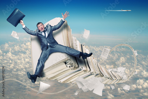 Photo: Businessman on stack of paperwork Businessman on stack of paperwork