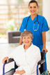 pretty young nurse pushing senior woman on wheelchair