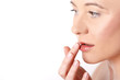 Junge Frau cremt sich ihre Lippen ein