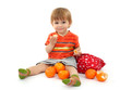 cute little boy eating tangerines, isolated on white