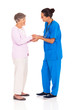 young female medical worker greeting senior woman