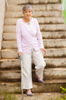 lonely senior woman standing by stairway
