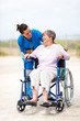 caregiver talking to disabled senior woman outdoors