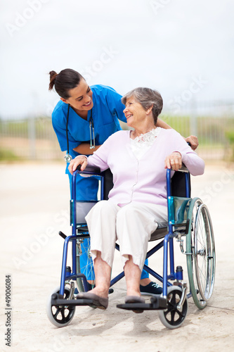 Photo: caregiver talking to disabled senior woman outdoors caregiver talking to disabled senior woman outdoors
