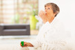 elderly woman drinking medicine at home