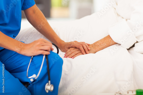 Photo: medical doctor holing senior patient's hands and comforting her medical doctor holing senior patient's hands and comforting her