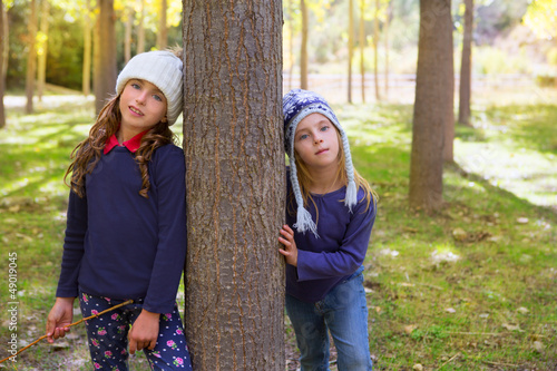 Photo: Autumn sister kid girls playing in forest trunk outdoor Autumn sister kid girls playing in forest trunk outdoor