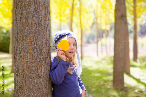 Photo: Child girl in autumn poplar forest yellow fall leaves in hand Child girl in autumn poplar forest yellow fall leaves in hand