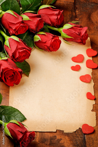 Photo: Frame with red roses and vintage paper Frame with red roses and vintage paper