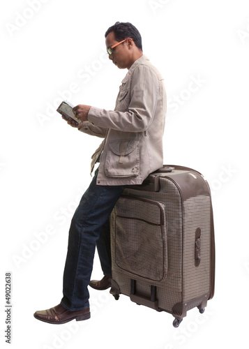 Photo: traveler holding sitting on big suitcase traveler holding sitting on big suitcase