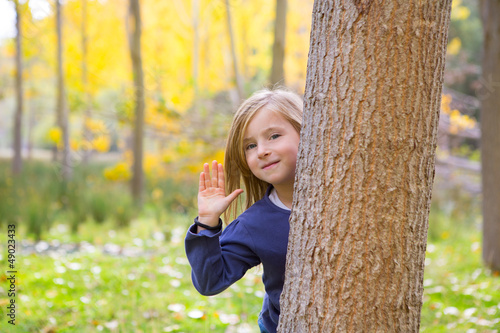Photo: Autumn forest with child girl greeting hand in tree trunk Autumn forest with child girl greeting hand in tree trunk