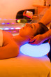 Woman enjoying therapy in spa with color therapy