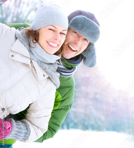 Photo: Happy Couple Having Fun Outdoors. Snow. Winter Vacation Happy Couple Having Fun Outdoors. Snow. Winter Vacation